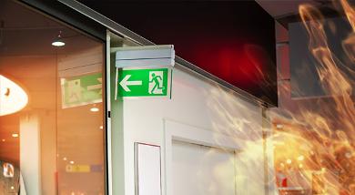 Fire exit sign on business premises with fire overlay